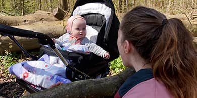 Billede af baby og voksen i skoven til træning ved FOF Aarhus