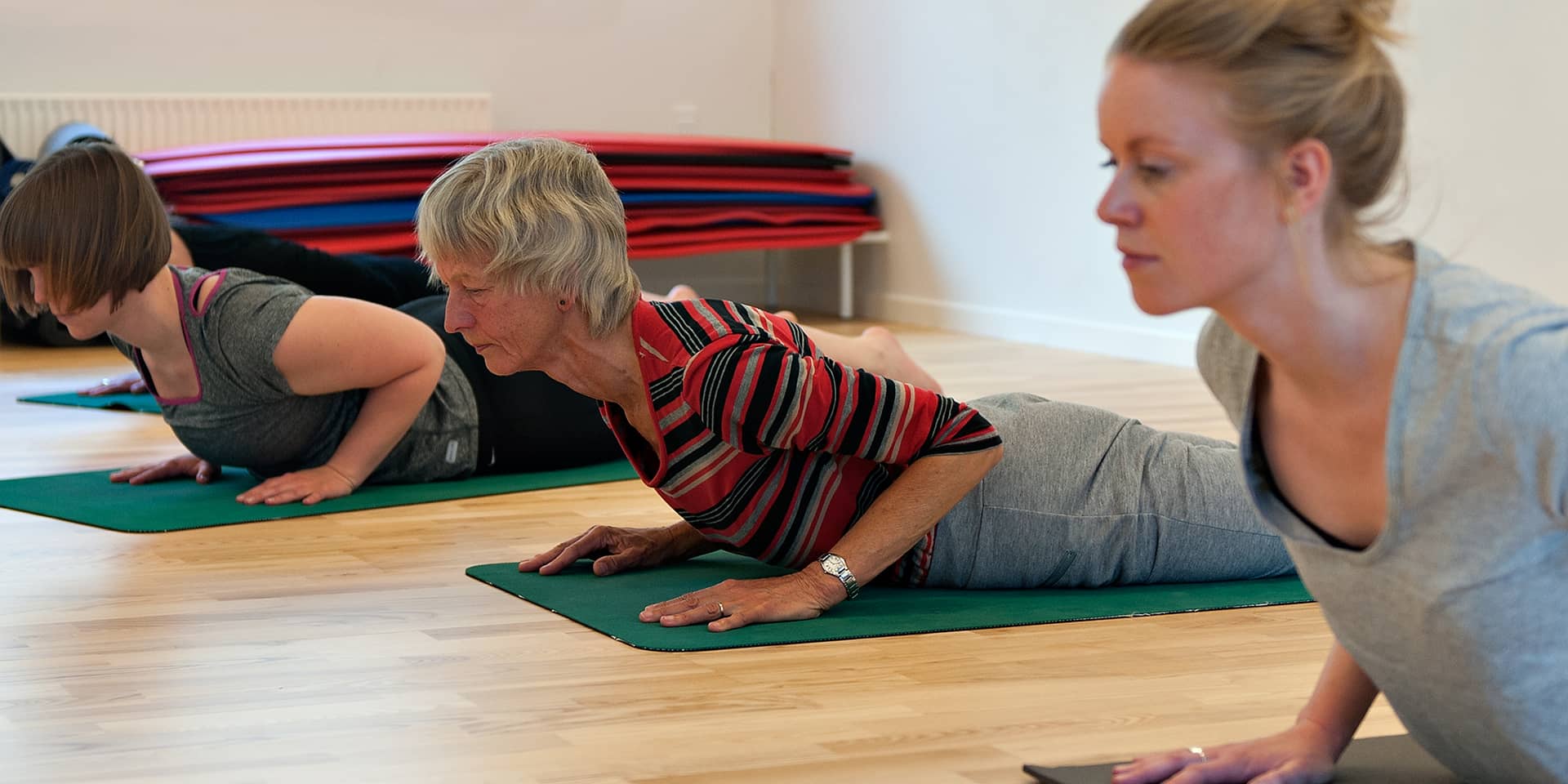 Kvinder der laver udstrækning på yogamåtte på kursus ved FOF Aarhus