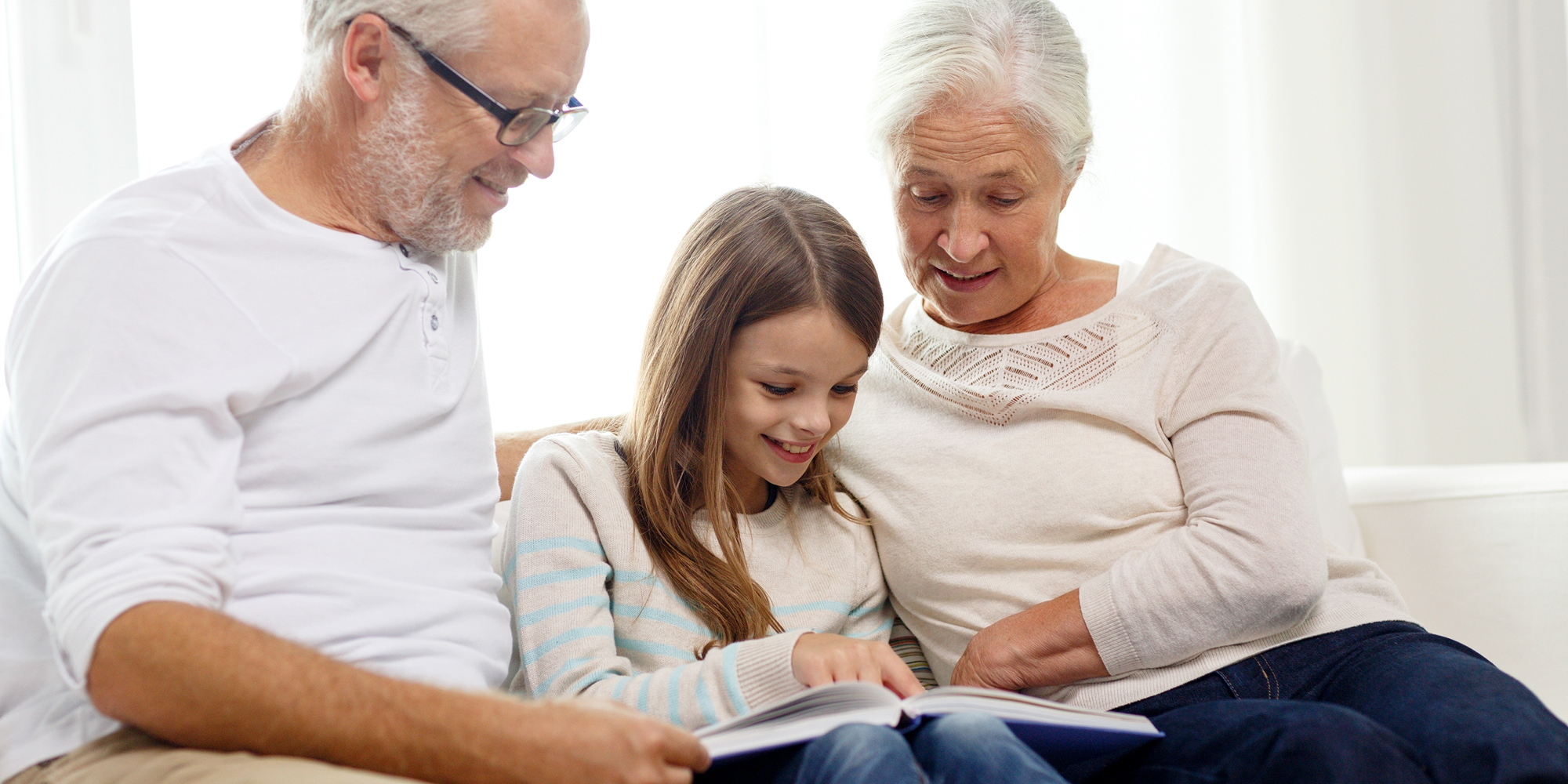 FOF Sønderjylland Lær at lave din egen fotobog bedsteforældre i sofa med barnebarn og bog
