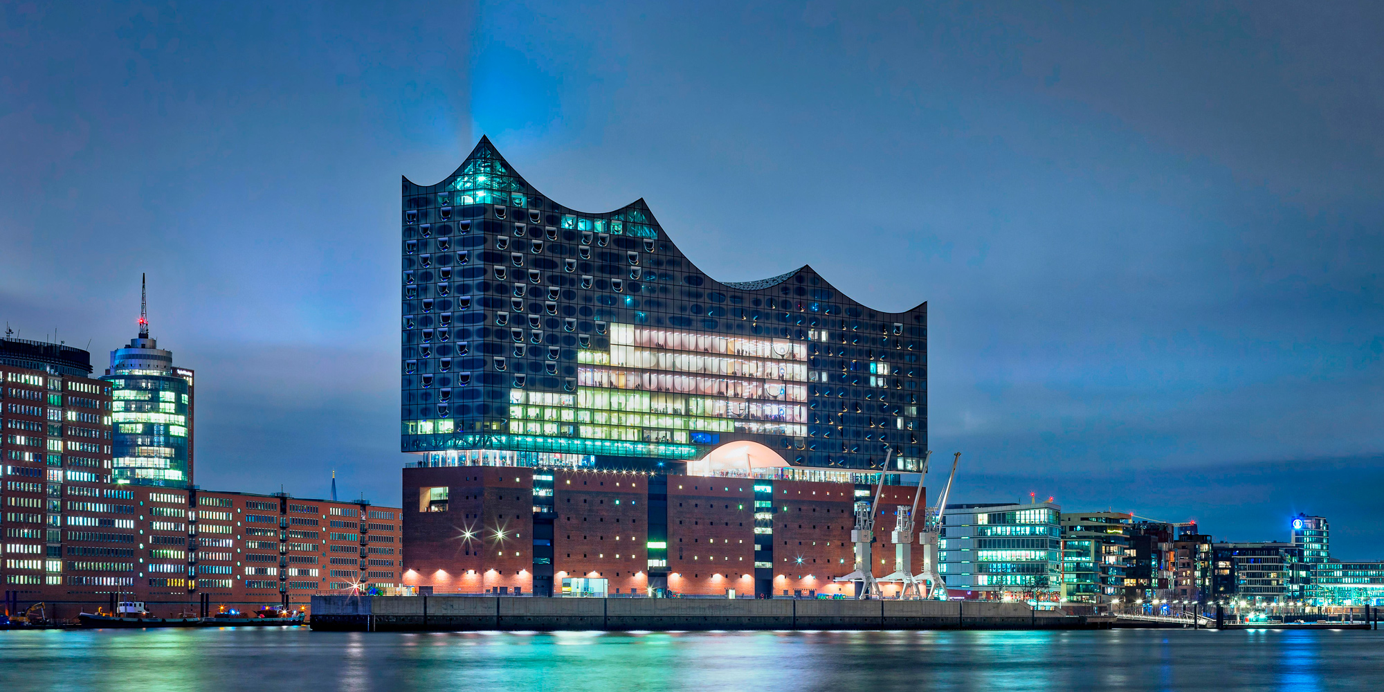 Elbphilharmonien og havnen i Hamburg oplyst om aftenen