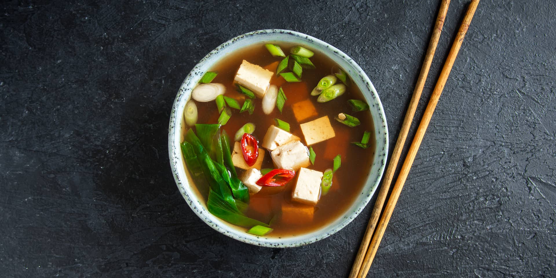 Asiatisk mad. Suppe, tofu og grøntsager i en skål, spisepinde