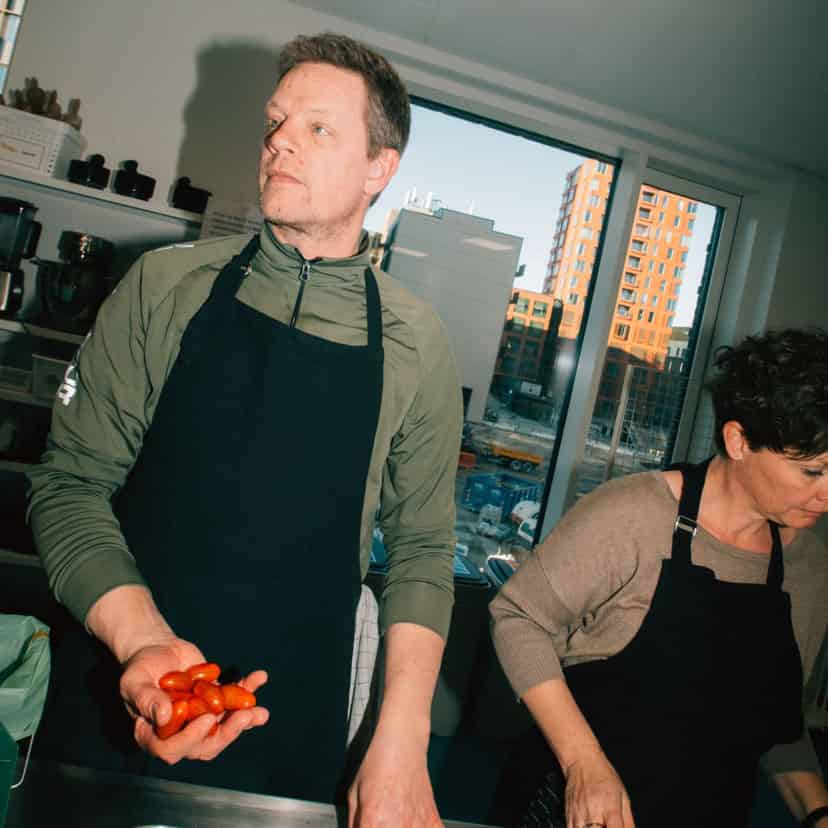 mand med forklæde laver mad