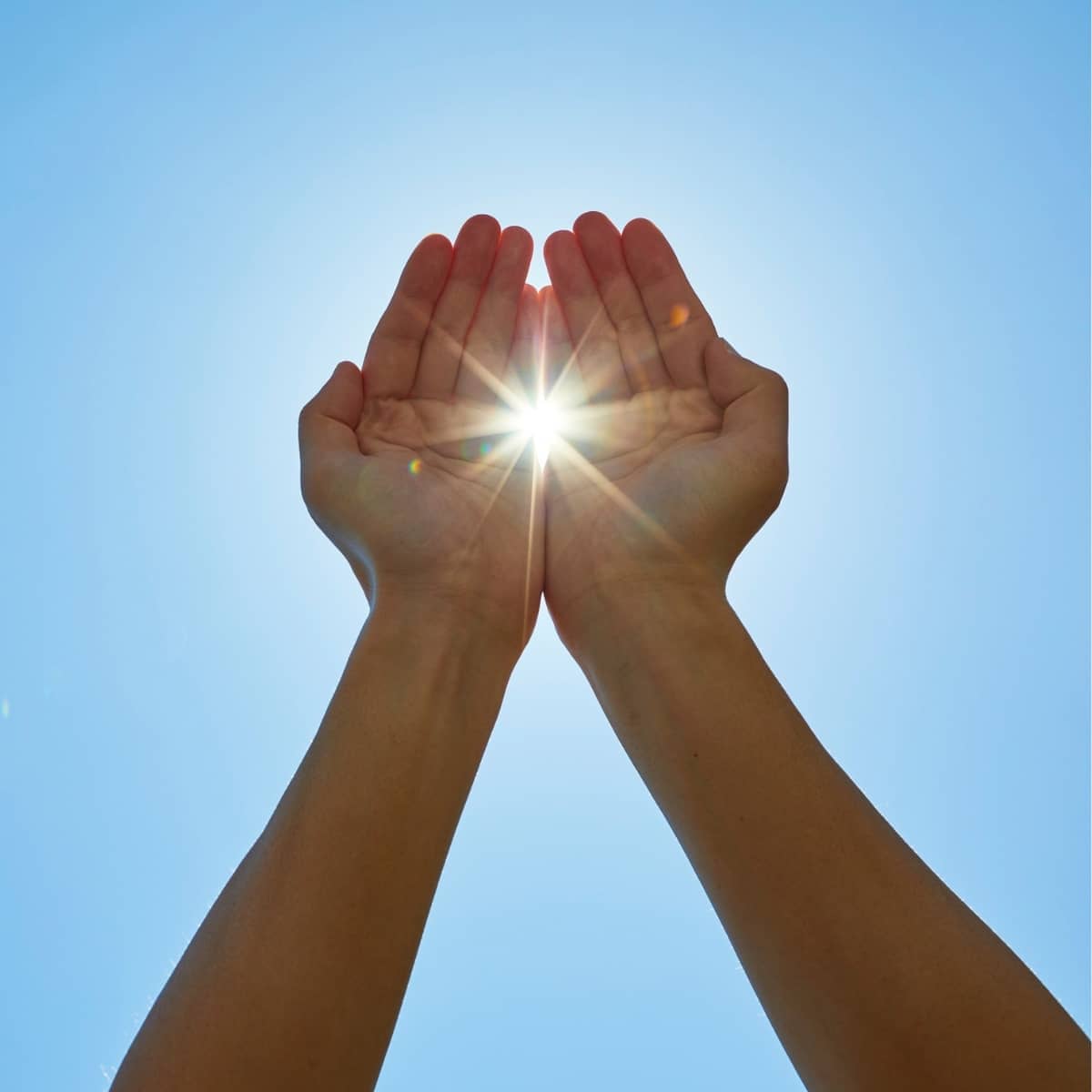 Hænder, der omkranser solen