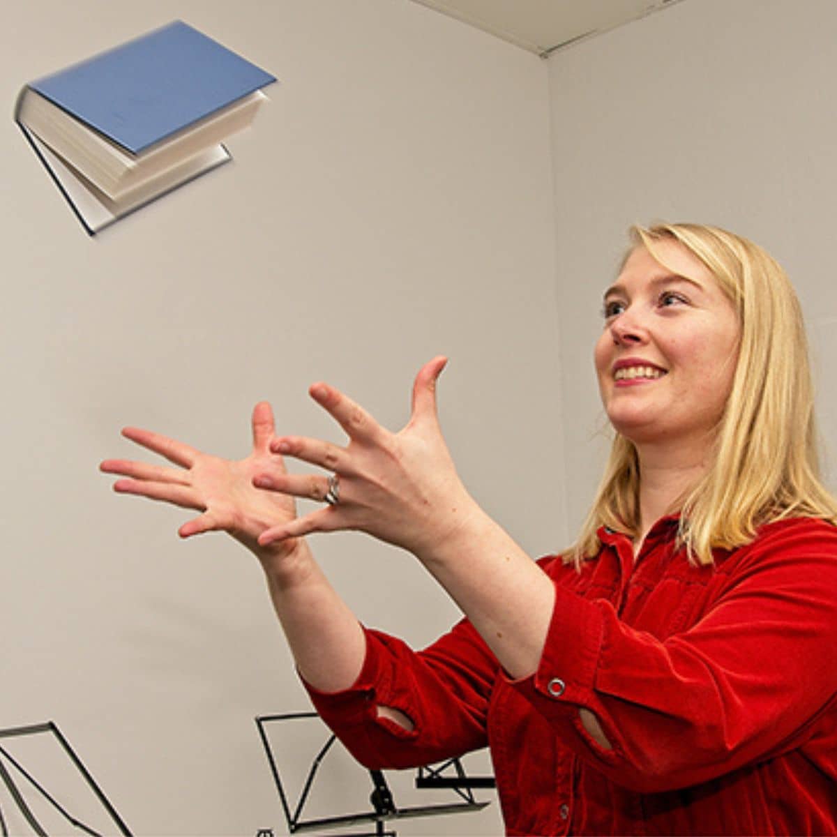 Tenna, der kaster med en sangbog. Hun går til sang på FOF Aftenskolen Aarhus.